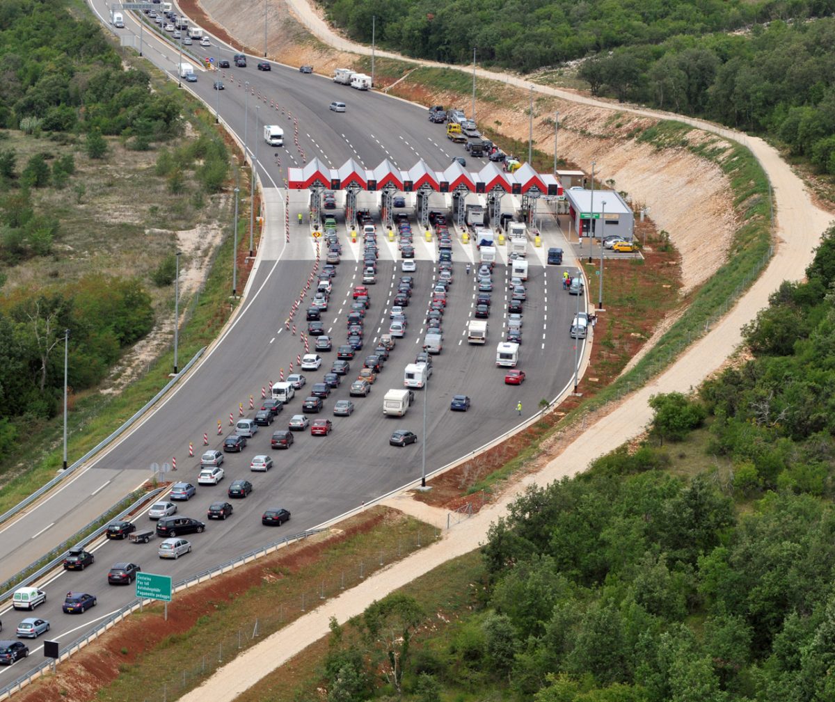 A busy highway check point seen from above during day time.