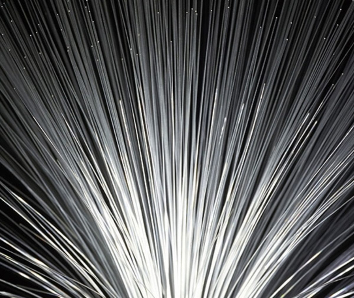 A close-up view of numerous thin, light-emitting fiber optic strands fanned out in all directions.