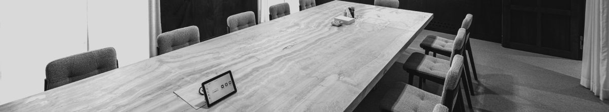 Black and white image of a long and empty meeting room table