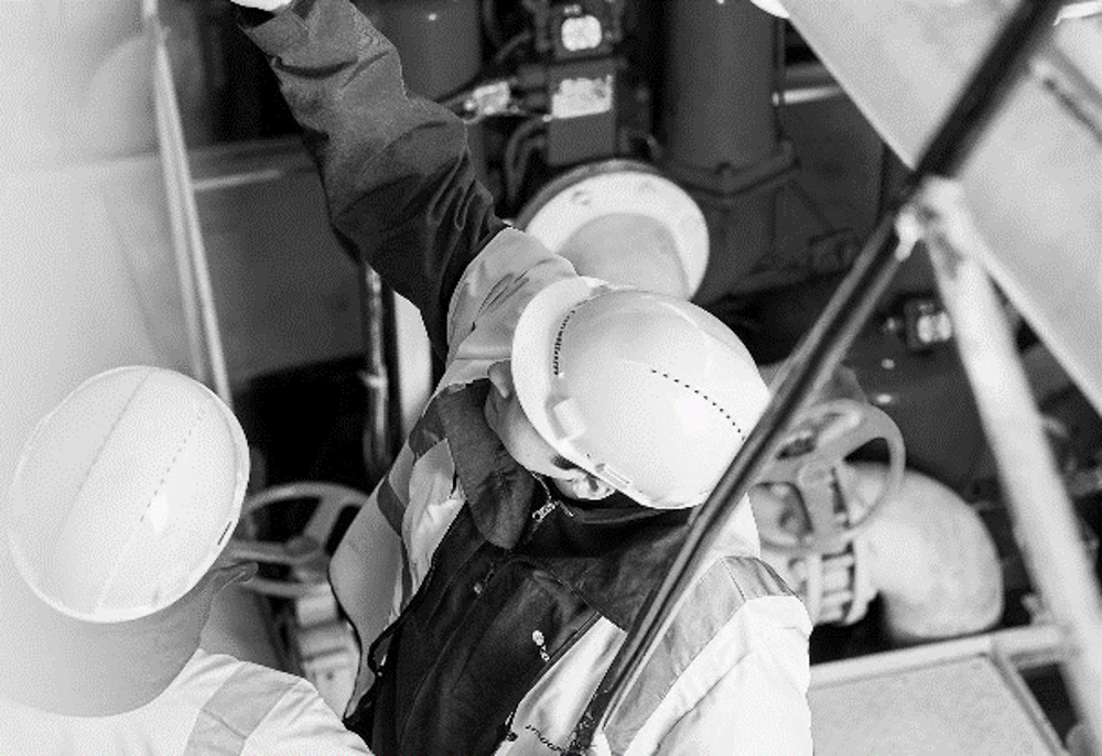 Black and white image of engineer in PPE gear working on-site